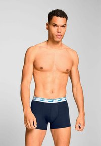 Navy blue boxer briefs with a wide white waistband featuring a blue Puma logo. Soft, stretch fabric with a snug fit.