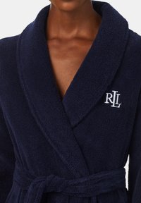 Granatowy szlafrok z frotte z kołnierzem szalowym, wiązanym w talii, z haftowanym logo "RL" na piersi. Miękka tekstura i gruby materiał.