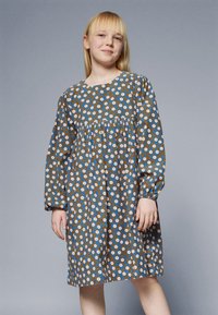 Abito floreale con sfondo marrone decorato con fiori blu e bianchi, maniche lunghe, vita arricciata e scollo rotondo.