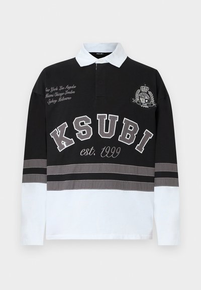 Μαύρο και άσπρο πόλο με μακριά μανίκια και γιακά, με κεντημένο λογότυπο της μάρκας, ρίγες και ονόματα πόλεων σε γκρι και λευκές αποχρώσεις.