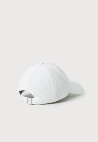 White baseball cap with a rounded crown, curved brim, stitched detailing, and an adjustable strap closure at the back.