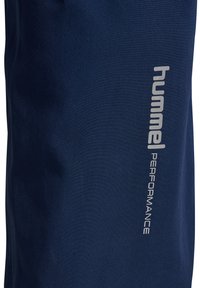 Tkanina granatowa z pionowym białym logo „hummel PERFORMANCE” nadrukowanym po prawej stronie.