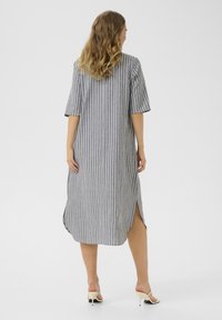 Robe rayée grise à manches courtes, coupe mi-longue, fentes sur les côtés, en tissu tissé, avec des rayures verticales blanches pour le contraste.