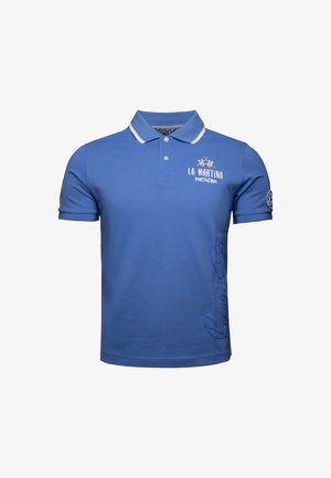 Sininen polo-paita, joka on valmistettu puuvillasta. Siinä on valkoinen kaulus ja brodeeraus. Sivulogo ja teksti helman varrella lisäävät yksityiskohtia. Klassinen malli.