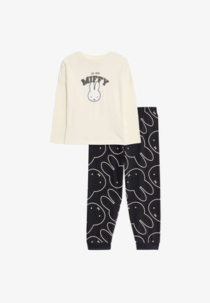 Ensemble de pyjama en deux pièces comprenant un haut crème à manches longues avec un graphique de Miffy et un bas noir avec un motif de lapins blancs. Tissu en coton doux.