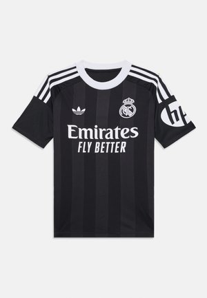 Maillot de football noir avec des rayures verticales, accents blancs, col ras du cou, arborant le logo Emirates et le blason du Real Madrid, trois rayures blanches sur les manches.