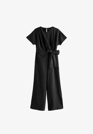 Tuta nera con design avvolgente, maniche corte, vita legata e gambe larghe. Il tessuto sembra essere testurizzato e leggero.