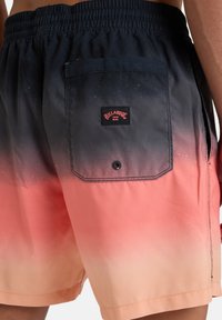 Billabong fürdőnadrág fekete és korall színű átmenettel. Hátsó zsebében patentos zárás és logó szalag található. Könnyű anyagból készült.