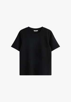 T-shirt noir à manches courtes en coton, avec un col rond et une coupe décontractée, au toucher doux et sans motifs visibles.