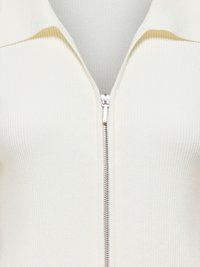 Bluză tricotată crem cu model reiat, cu fermoar metalic argintiu pe centru și guler larg.