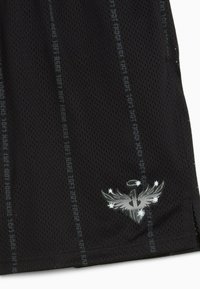 Shorts neri in rete con un logo riflettente di un uccello con stelle. Accenti di testo verticale decorano il tessuto, migliorando la presa e la traspirabilità.