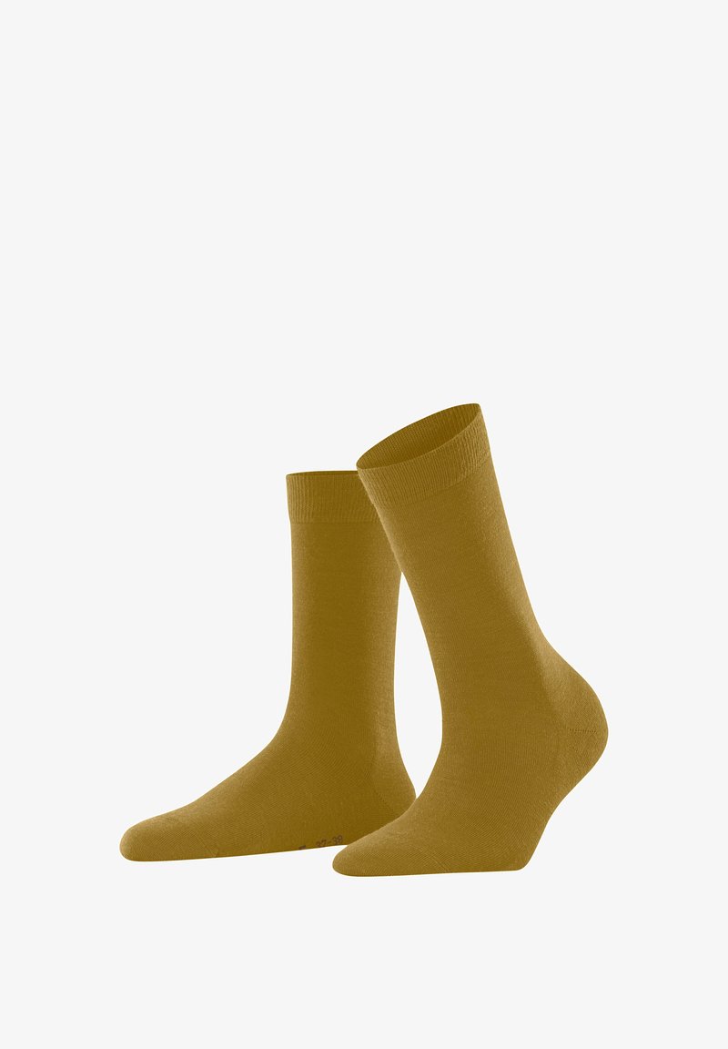 Calcetines tobilleros de color amarillo mostaza con una textura suave, puños acanalados y altura hasta la mitad de la pantorrilla, diseñados para la comodidad y el uso diario.