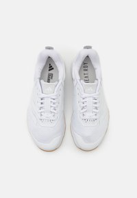 Witte sportieve schoenen met een ademend bovenwerk van mesh, rubberen zool, vetersluiting en gestructureerde details aan de zijkanten.