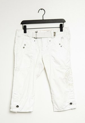 Witte cropped broek met voorzakken en knopdetails, hangend aan een zwarte kledinghanger tegen een witte achtergrond.