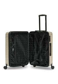 Hard-shell beige koffer met vier wielen, telescopische handgreep en een geopend interieur dat zwarte stoffen voering toont met banden en ritscompartimenten.
