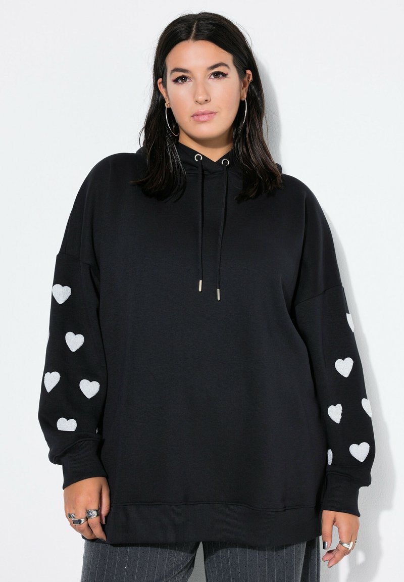 Sudadera negra con un corte holgado, capucha con cordón y patrones de corazones plateados en las mangas. Tejido suave con puños y dobladillo acanalados.