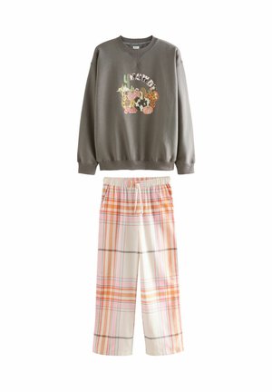 Grauer Pullover mit einem mehrfarbigen Grafikdesign und lockeren Karotten-Hosen in Orange und Weiß mit einem elastischen Bund.