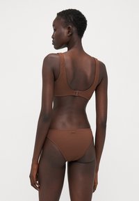 Brown textured bikini with a scoop back and wide straps; features a clasp closure and a matching low-rise bottom.