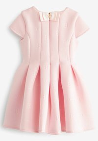 Różowa sukienka w kształcie litery A wykonana z teksturowanej tkaniny z tłoczonymi literami. Posiada krótkie rękawki typu cap, kokardę z tyłu oraz zapięcie na suwak.