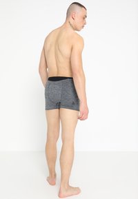 Donkergrijze herenboxershorts met een getailleerd ontwerp, een elastische zwarte tailleband en een klein merkje aan de linkerkant.