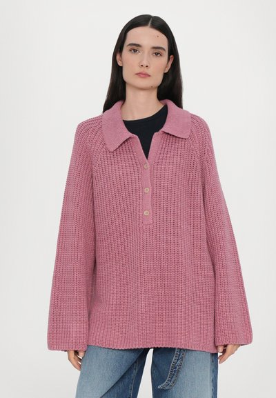 Suéter de punto rosa con cuello, que presenta una parte delantera abotonada, un ajuste relajado y mangas largas. Textura tejida con un diseño suelto y cómodo.