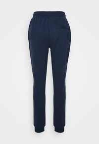 Dunkelblaue Sweatpants aus weichem Baumwollgemisch. Mit elastischem Bund, schmal zulaufenden Beinen und einer hinteren Gesäßtasche. Glatte Textur.