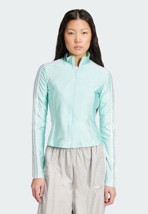 Mint green zip-up jacket with long sleeves, white three-stripe accents on shoulders, and logo on chest. Smooth, lightweight fabric.