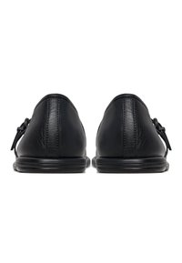 Zapatos de cuero negro con una textura suave, tacones redondeados y un diseño minimalista. Cuenta con una suela de goma elegante y costuras sutiles.