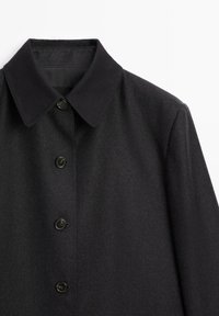 Black wool blend coat featuring a classic collar, five buttons, and a smooth texture, with a fitted silhouette and no visible patterns.
