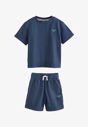 Granatowy krótki rękaw koszula i pasujące krótkie spodenki z zielonymi logo "Superdry & Co" i białym sznurkiem w spodenkach.