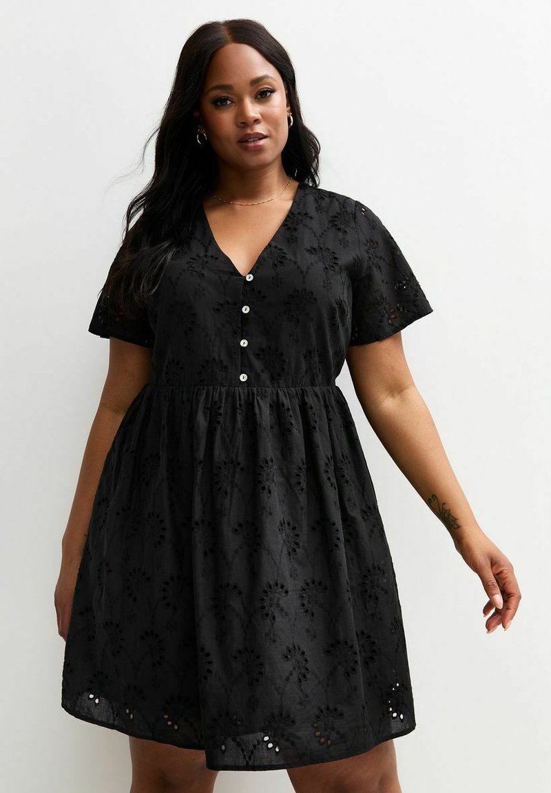 Black short-sleeved dress with a V-neck, button front, and floral embroidery. Flared skirt with delicate cut-out accents at the hem.