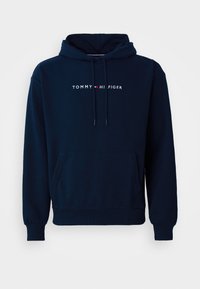 Hoodie bleu marine avec une poche avant, cordons de serrage ajustables et logo "TOMMY HILFIGER" en lettres blanches sur la poitrine.