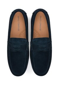 Granatowe zamszowe loafersy o gładkiej teksturze, zaokrąglonym nosie, przeszyciach oraz perforowanych akcentach na jasnobrązowej wkładce.