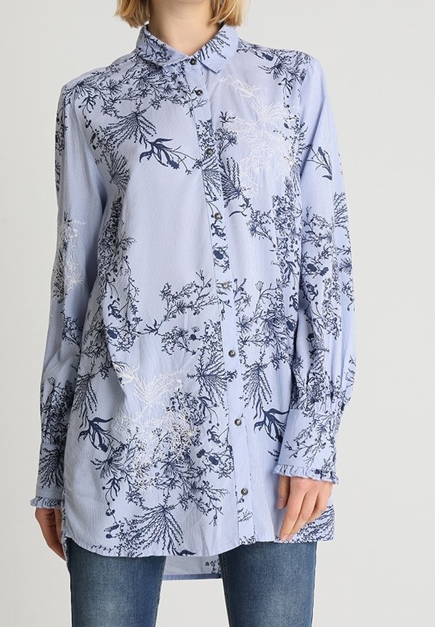 Vaaleansininen napillinen paita, jossa on merkkikuosiset kukat tummansinisellä ja valkoisella. Ominaisuudet: pitkät hihat, kaulus ja rento malli. Pehmeä, tekstuuriinen kangas.