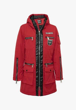 Veste rouge à capuche avec fermetures éclair noires, plusieurs poches zippées et écussons portant les inscriptions "ARMY-XX62" et "CIPO & BAXX 666".