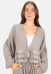 Grauer strukturierten Cardigan mit einem verkürzten Design, im Vorderteil mit einer Bindung und Spitzenbesatz. Lange Ärmel und geschichteter, gewellter Saumdetail.