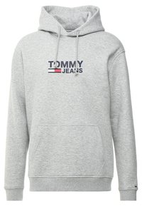 Sudadera gris con un bolsillo canguro en el frente, cordones en la capucha y un logotipo impreso "TOMMY JEANS" en azul marino y rojo en el pecho.