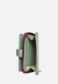 Portafoglio in pelle verde con una cerniera bordeaux a contrasto. Presenta scomparti per carte e una finitura texturizzata. Si apre con una chiusura a scatto.