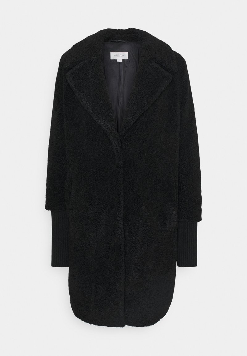 Czarny płaszcz z sztucznego futra z głębokim dekoltem w kształcie V, dużymi klapami i długimi rękawami. Posiada ściągacze z ribbowanego materiału oraz gładką podszewkę.