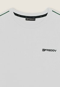 T-shirt bianca a maniche corte con colletto rotondo, caratterizzata da strisce laterali verdi e un piccolo logo "FREDDY" nero sul davanti.