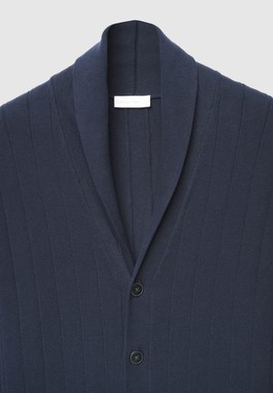 Cardigan bleu marine à motif côtelé texturé, avec un col châle et trois boutons noirs à l'avant.
