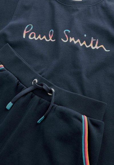 Tmavě námořnická mikina se znakem "Paul Smith" v pastelových barvách. Odpovídající teplákové kalhoty mají šňůrku v pase a barevný pruh po straně.