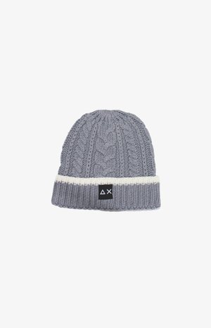 Beanie grigio lavorato a maglia con motivo a treccia, dotato di un risvolto a coste bianche e di un'etichetta nera con logo. Texture morbida, cima arrotondata.