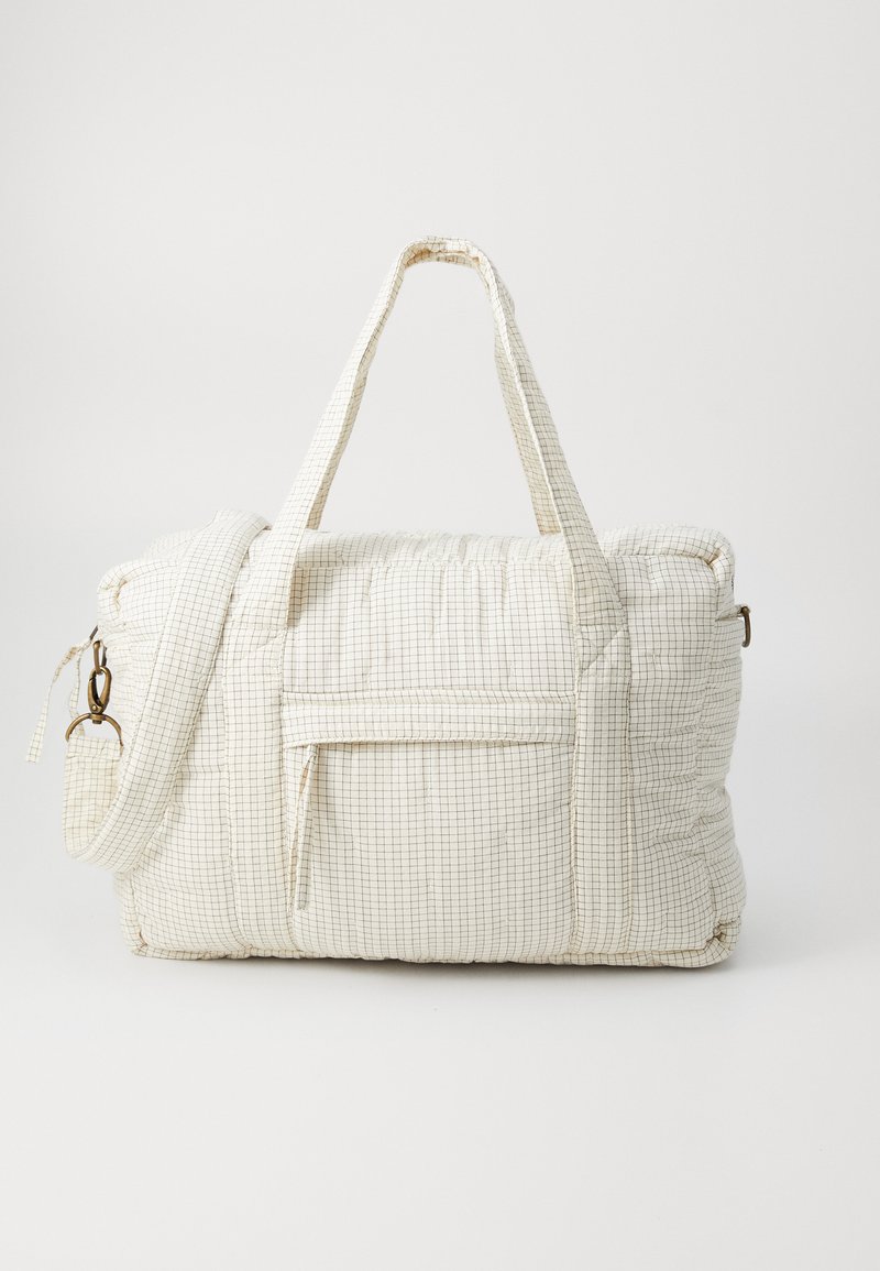 Sac blanc matelassé avec un motif à carreaux, poignées courtes, bandoulière ajustable, poche zippée et une finition douce et texturée.