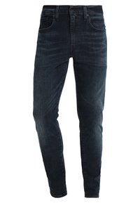 Mörkblå skinny jeans i denim, med medelhög midja, femfickorsdesign och subtila blekningar längs benen.