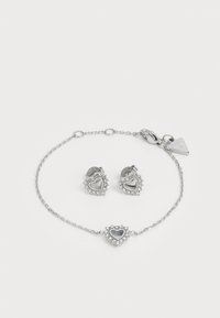 Zilveren sieradenset met hartvormige oorringen en een bijpassende armband, versierd met heldere kristallen en een delicate kettingontwerp.