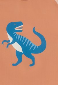 Orange fabric with a blue dinosaur graphic featuring a white belly and blue stripes on its back, standing in a walking pose.