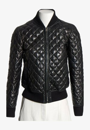 Chaqueta bomber de cuero negra acolchada con cremallera frontal, cuello, puños y cintura acanalados, mostrada en un torso de maniquí blanco.