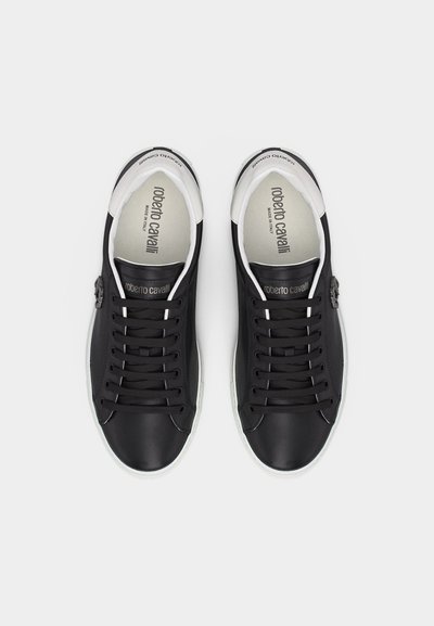 Paire de baskets basses noires avec semelles et lacets blancs, de marque "roberto cavalli" à l'intérieur et sur la languette.