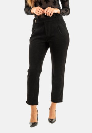 Pantalones de pana negros con un corte entallado, que cuentan con una cintura alta, dos botones y un dobladillo recortado. Textura suave con ribetes verticales.